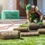 professional-landscaper-installing-new-grass-turfs-NSDH26H.jpg
